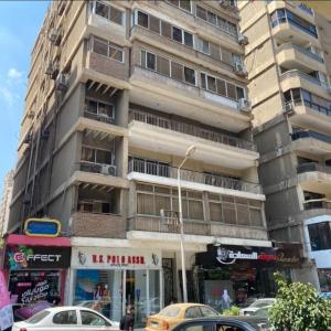 a tall building with cars parked in front of it at Alhejaz Luxurious Apartment in Cairo +18 photos