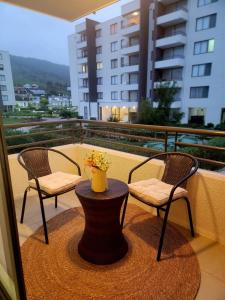 two chairs and a table with a vase on a balcony at Papudo, Tus vacaciones soñadas!!! in Papudo +30 photos