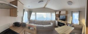 a living room with a couch and a tv in a caravan at MLF caravan rental marine holiday park in Rhyl