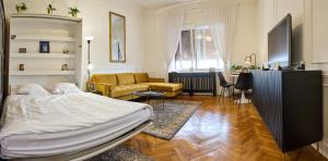 a living room with a bed and a couch at Piac 16 apartman a belváros szívében in Debrecen