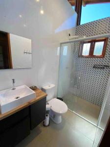 a bathroom with a toilet and a sink and a shower at Chalé na Cachoeira dos Machados II - Bueno Brandão in Bueno Brandão +14 photos
