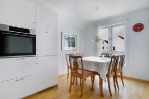 a kitchen with a table with chairs and a tv at Silent Seaview Luxury Apartment Grasholmen in Stavanger