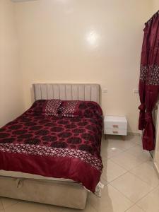 une chambre avec un lit avec une couette rouge dans l'établissement Appartement skhirat, à Skhirat 9 autres photos