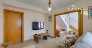 a living room with a couch and a tv at Burgau Charming House Villa in Burgau