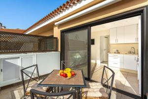 a table and chairs with a bowl of fruit on it at As de Casas - Parque Albatros 2 in San Miguel de Abona
