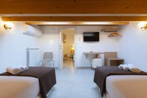 a hotel room with two beds and a desk at Bed and Breakfast Nilu' in Castellammare del Golfo