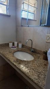a bathroom counter with a sink in a room at Loft Lagoa Areal in Araruama +1 photo