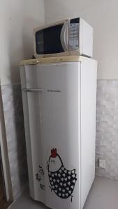 a microwave sitting on top of a refrigerator at Loft Lagoa Areal in Araruama