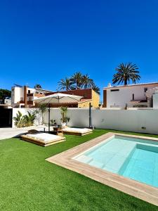 a backyard with a swimming pool and green grass at Serena Villa in Benicarló