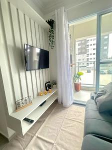 Una sala de estar con un televisor en la pared. en Complete apartment near the airport, en São José dos Pinhais
