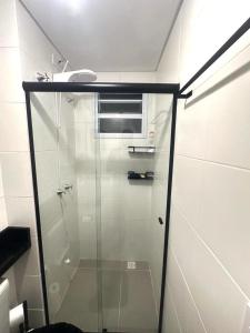 una ducha con puerta de cristal en un baño en Complete apartment near the airport, en São José dos Pinhais