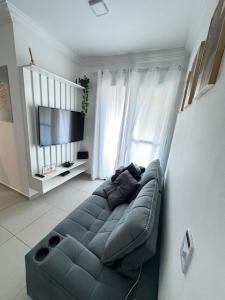 Una sala de estar con un sofá y un televisor de pantalla plana. en Complete apartment near the airport, en São José dos Pinhais