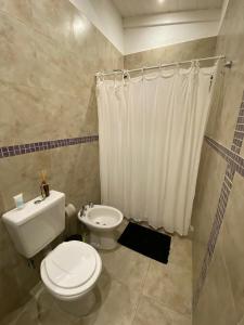 a bathroom with a toilet and a shower curtain at Espectacular casa en Costa Esmeralda, Barrio Deportivo in Costa Esmeralda