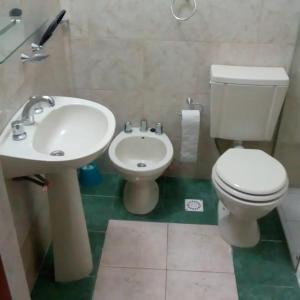 ラ・クンブレにあるPaigenの白いトイレと洗面台のあるバスルーム