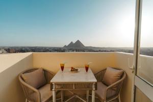 a table and chairs on a balcony with a view of a mountain at Orienta view pyramids in Cairo