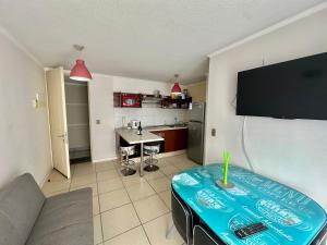 a living room with a table and a flat screen tv at Dpto Playa Casino Marina Sol in Coquimbo