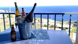 two bottles of wine in a bucket on a table with glasses at Mãe de Deus - Caniço - Madeira in Caniço