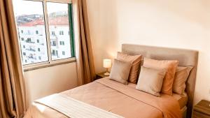 a bedroom with a bed with a window at Mãe de Deus - Caniço - Madeira in Caniço