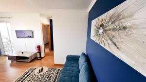 a living room with a couch and a blue wall at Mãe de Deus - Caniço - Madeira in Caniço