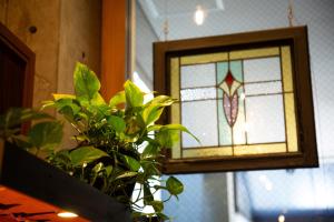 a stained glass window with a plant in front of it at Hotel Landmark Umeda in Osaka