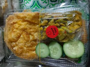 a plastic container of food with cucumbers and a sticker at Maruay in Suratthani