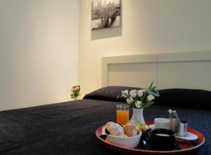 a tray of food on a bed with a plate of food at Casual Stay Galileo in Reggio di Calabria
