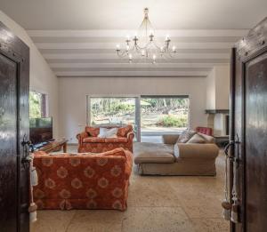 a living room with a couch and a chandelier at Sintra - Praia Grande Village in Colares