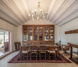 a dining room with a table and chairs and a chandelier at Sintra - Praia Grande Village in Colares