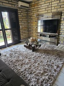 a living room with a stone wall and a fireplace at Casa de pedra in Arroio do Silva