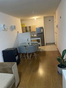 a living room with a table and a kitchen at Departamento por día in Temuco