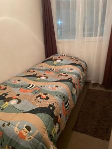 a bed with a comforter with cows on it at Departamento por día in Temuco