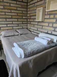 a bed in a brick wall with towels on it at Casa de pedra in Arroio do Silva +12 photos