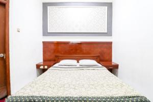 a bedroom with a bed with a window and a bedspread at Hotel Limaran 1 in Yogyakarta +120 photos