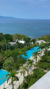 einen Luftblick auf einen Pool mit Palmen und das Meer in der Unterkunft Gu-F1 in Higuera Blanca