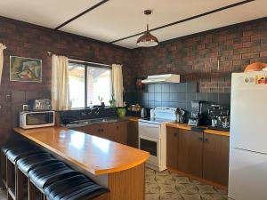 a kitchen with a counter and a white refrigerator at Suur Kodu- Beachfront House plus Tiny Home in Sellicks Beach