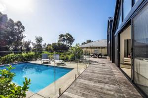 una piscina en una terraza junto a una casa en Ember and Aqua - Luxury Barnhouse on the Golf Course, en Dunsborough