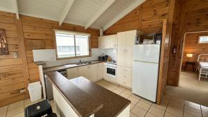 a kitchen with a white refrigerator and a table at Dolphin in Apollo Bay