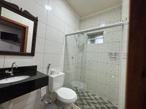 Un baño con inodoro, lavabo y ducha. en Caminho das cataratas, en Foz do Iguaçu