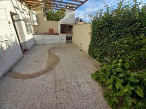 a courtyard of a house with a hedge at Alquiler Temporario Casa Cervantes in Paraná