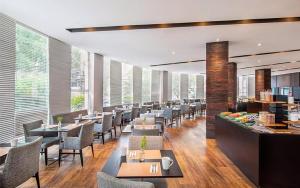 Un restaurante con mesas, sillas y ventanas. en MLA Flat Hotel Moema Ibirapuera - Completo e ótima localização, en São Paulo
