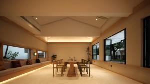 a dining room with a table and chairs and windows at songzhiyu3平江路 in Suzhou