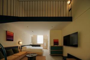 a bedroom with a bed and a couch and a tv at songzhiyu3平江路 in Suzhou