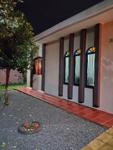 a house with two windows and a flower bed in front at Quartos em casa compartilhada na Cidade Canção Maringa in Maringá