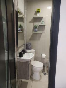 a small bathroom with a toilet and a sink at Minisuit, Loja in Loja +2 photos
