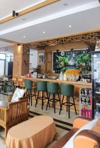 a restaurant with a bar with green chairs at Earstring Hanging Gardens Hotel in Dali Ancient Town +33 photos