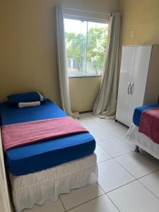ein kleines Schlafzimmer mit einem Bett und einem Fenster in der Unterkunft Beira Mar in Aracaju