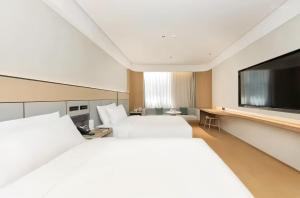 Ένα ή περισσότερα κρεβάτια σε δωμάτιο στο JI Hotel Beijing Wukesong Jinghui Plaza