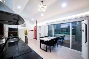 a kitchen and dining room with a table and chairs at Hamdeok Poolvilla Pension Lamborghini in Jeju