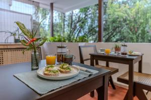 a table with a plate of food on it at Casa Lúmina - Hotel Boutique y Spa, San Benito in San Salvador