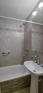 a bathroom with a sink and a bath tub and a mirror at Saavedra - Hermoso y con cochera opcional in Santa Fe
